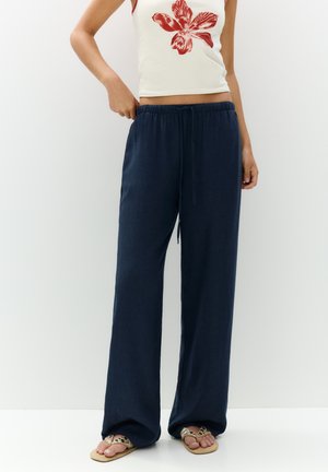 Pantalons larges bleu marine en tissu léger, dotés d'une taille élastique et d'un cordon de serrage pour un ajustement personnalisé.
