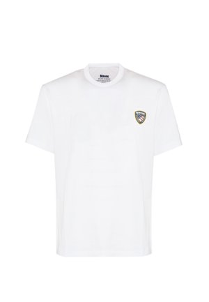T-shirt bianca in cotone con scollatura rotonda, maniche corte e una toppa sul petto sinistro con un logo a forma di scudo blu e rosso.