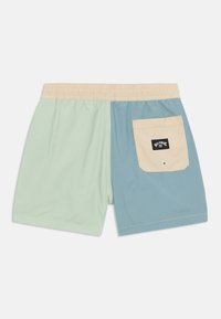 Shorts de bain bicolores avec un côté gauche vert clair et un côté droit bleu, avec une taille beige et une poche arrière avec un patch logo.