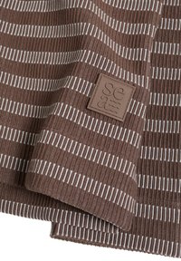 Tissu marron côtelé avec des rayures horizontales blanches, présentant une étiquette carrée marron embossée du mot « sea ». Bords du tissu positionnés visibles.