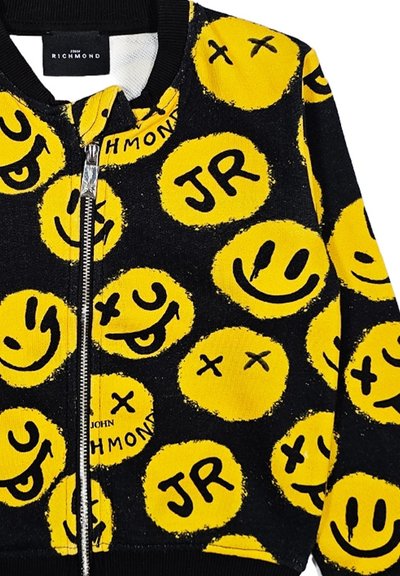 Giacca bomber nera con faccine sorridenti gialle e design "JR". Realizzata in morbido tessuto con zip frontale e colletto a coste.