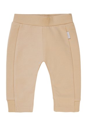 Pantalons en coton beige avec une taille et des poignets côtelés. Dispose de deux coutures latérales et d'une étiquette sur le côté gauche. Texture lisse et design fuselé.