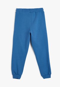 Blaue Sweatpants aus weichem Material, mit einem elastischen Bund und schmalen Bündchen, einer glatten Textur und ohne sichtbare Muster.