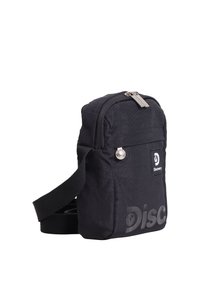 Schwarze kompakte Schultertasche mit einem Hauptfach mit Reißverschluss, einer Fronttasche und dem "Discovery"-Logo auf der Vorderseite.