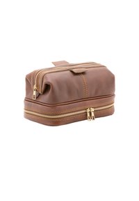 Bruine leren cosmetica-tas met twee gouden ritsen, een handvat aan de bovenkant en zichtbare stiknaaddetails. Rechthoekige vorm met een gestructureerde afwerking.