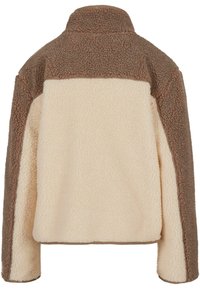 Sudadera de forro polar marrón y crema con cuello alto, que presenta una superficie texturizada y un diseño de paneles en contraste a lo largo de los hombros.