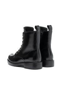 Botas de tobillo de cuero negro con un acabado liso, diseño de cordones y dos tiradores. Presentan una puntera redonda y una suela de goma resistente.