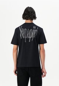 Sort bomuld t-shirt med et stort gråt "Napapijri" logo på ryggen, korte ærmer, rund hals og en afslappet pasform.