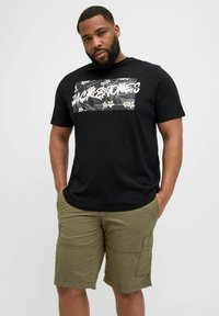 Black cotton t-shirt with a floral graphic design featuring white text, paired with khaki cargo shorts with side pockets and a relaxed fit.