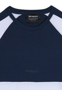 T-shirt blu navy con maniche raglan bianche, presenta un colletto rotondo e un logo goffrato discreto sul davanti. Materiale in cotone morbido.