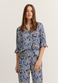 Blue and white paisley print shirt with rolled sleeves, collared design, and glossy texture; paired with matching patterned pants.