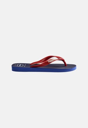 Kék flip-flop papucs texturált talppal és piros pántokkal, melyeken fehér márkajelzés látható, fehér háttéren.