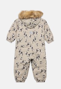 Μπεζ ολόσωμη φόρμα με επένδυση, διακοσμημένη με ζωικά μοτίβα, διαθέτει κουκούλα με επένδυση από ψεύτικη γούνα και ελαστικά μανσέτες για άνετη εφαρμογή. Σημαντικά σχέδια περιλαμβάνουν ταράνδους και αλεπούδες.