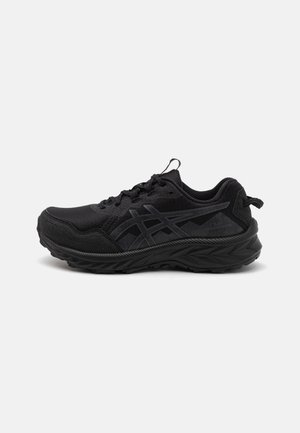 Zapato deportivo negro con malla y tejido texturizado, que presenta un diseño elegante, suela moldeada y acentos de logo en tono. Cierre con cordones.