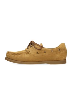 Beżowy zamszowy but typu boatshoe z brązowymi skórzanymi sznurówkami, bocznymi oczkami i płaską gumową podeszwą, widoczny z lewej strony.