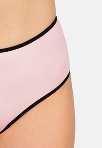 Kalhotky s vysokým pasem vyrobené z jemné růžové tkaniny s černým elastickým obložením. Mají hladkou strukturu a klasický střih.