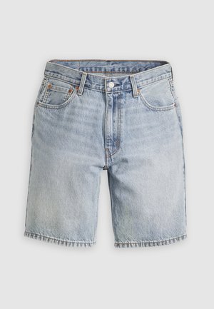 Lyseblå denimshorts med knaplukning, bæltestropper samt lommer foran og bagpå, vist mod en ensfarvet baggrund.