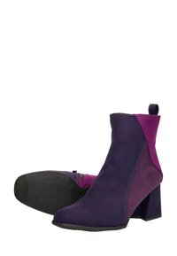 Bottines en suède violet et fuchsia avec un talon bloc, dotées d'une fermeture éclair latérale et d'une tirette pour un enfilage facile. Texturé avec une finition lisse.
