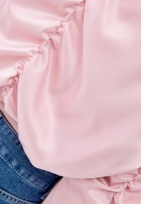 Rosa satinblus med samlad detaljering, med en slät textur och en lätt lyster, kombinerad med denim i nederkant.