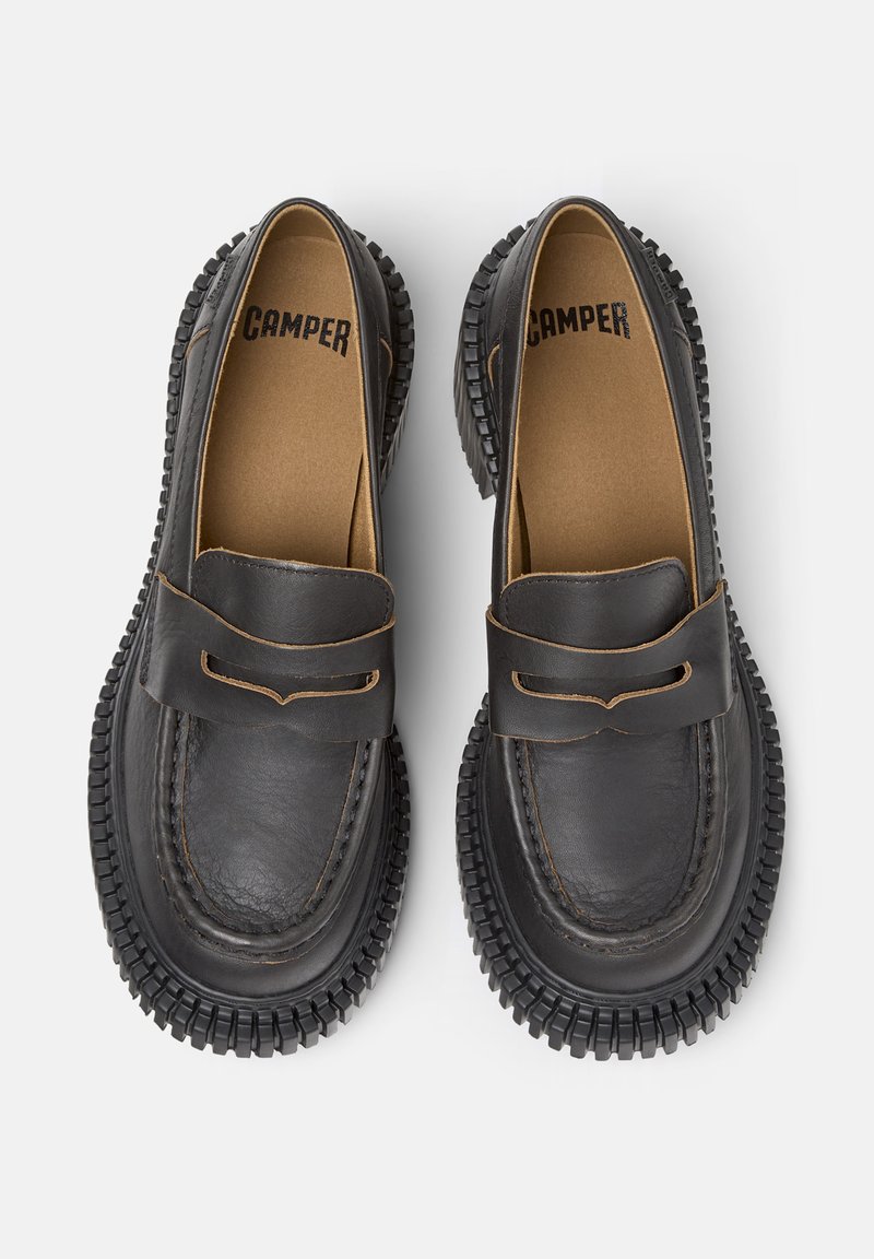 Schwarze Lederloafers mit runder Zehe, gesteppten Details und einer Gummisohle mit strukturiertem Profil. Brauner Akzent am oberen Band.