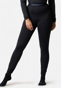 Svarta leggings i elastiskt tyg med hög midja och en logotyp, slät textur och en åtsittande design som formar benen.