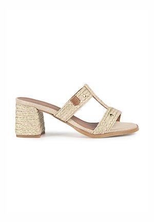 Sandalias de tacón beige con dos correas trenzadas, que presentan un acabado texturizado y un tacón trenzado, complementadas con pequeñas piezas metálicas de acento.