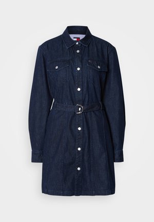 Mørk denimkjole med lange ermer, knapfront, brystlommer og belte i taljen. Har en klassisk krage og sølvfarget hardware.