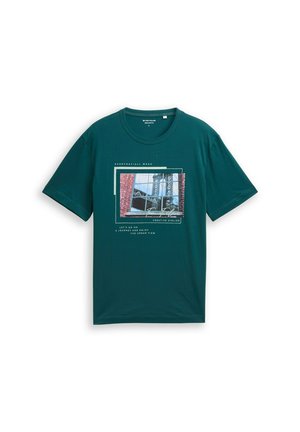 Tyrkysové tričko s krátkym rukávom s fotografickou potlačou okna a priemyselnej konštrukcie, vrátane textu "Everyday/All week" a "Creative Atelier."