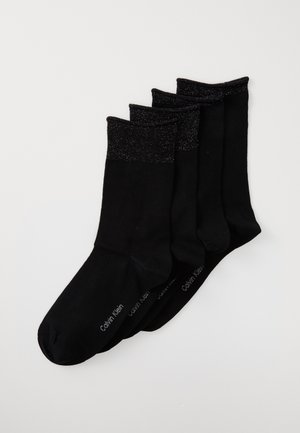 Four pairs of black calf-length socks with sparkly cuffs, stacked diagonally on a white background, featuring subtle brand text on the sole.