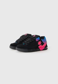 Black suede sneakers with pink and blue accents. Features include laces, logo detail, and a textured sole design.