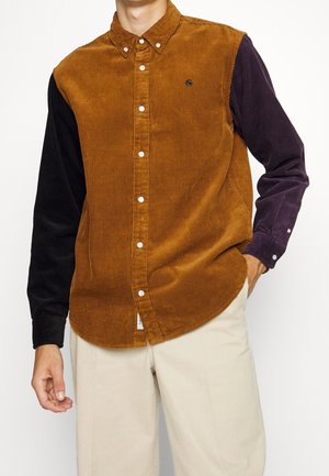 Corduroy shirt met een bruine voorkant, zwarte linkermouw en paarse rechtermouw, met een button-down kraag en een klein logo. Getextureerde stof.