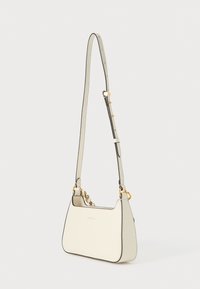 Δερμάτινη τσάντα ώμου κρεμ χρώματος με χρυσές μεταλλικές λεπτομέρειες, καμπυλωτό σχήμα και μαύρο περίγραμμα. Ρυθμιζόμενο λουρί, μινιμαλιστικός σχεδιασμός και λογότυπο της μάρκας.
