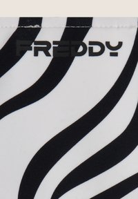 Tekstiili, jossa on musta ja valkoinen seepra-raita, joka on sileä ja jossa on näkyvä musta "FREDDY"-logo. Suunnittelussa vuorottelevat kaaret ja viivat.