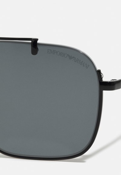Juodos saulės akinių su pilkais lęšiais, turinčių elegantišką stačiakampį dizainą, plonas juodas šoneles ir įspaudą "Emporio Armani" logotipą ant lęšio.