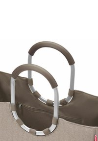 Zwei robuste ovale Griffe mit braunen Griffen, die an einer beigefarbenen und braunen Stofftasche mit einem Reißverschlussfach befestigt sind.