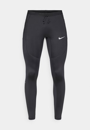 Black athletic leggings with a slim fit, made from stretchy material, featuring a drawstring waist and a white Nike logo on the left thigh.