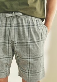 Grau karierte Shorts aus weichem Stoff mit einem elastischen Bund und Kordelzug sowie seitlichen Taschen.