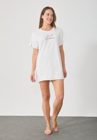 Fehér pamut hálóing kerek nyakkivágással, rövid ujjal és fekete színű "Sweet Dreams" felirattal. Puha tapintású, térd középig érő fazon.