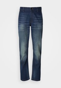 Tumesinised teksapüksid sirge sääre lõikega, esiküljel tuhmumisega, nööbiga tõmblukuga ja tavalise viie tasku disainiga.