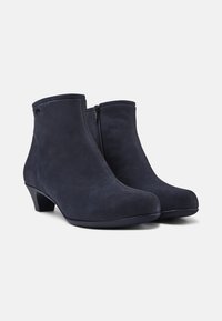 Stivaletti alla caviglia in suede blu navy con una superficie liscia, tacco leggero, cuciture frontali e zipper laterale. Design a punta arrotondata.