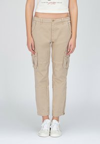 Beiga cargobyxor med en figurnära design, framknäppning och flera sidofickor. Tillverkade av slitstarkt tyg med en slät textur.