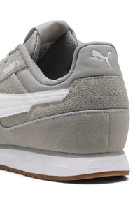 Gray suede sneaker with white leather stripes, rubber sole, padded collar, and embossed “SOFTRIDE” branding on the heel.