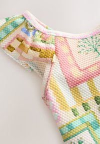 Buntes Strickoberteil mit einer strukturierten, blasenartigen Musterung in pastellfarbenen Tönen von Rosa, Grün und Gelb. Mit Rüschen an den Ärmeln.