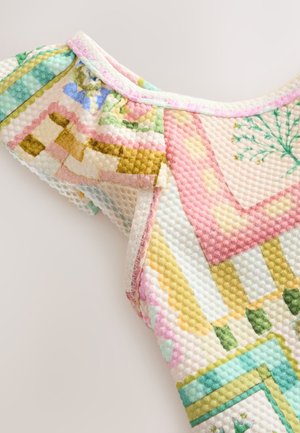 Haut tricoté coloré présentant un motif texturé en forme de bulles dans des tons pastel de rose, vert et jaune. Détail de manches à volants.