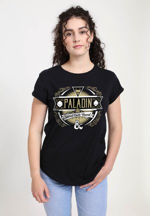 Sort bomulds t-shirt med en hvid og guldfarvet grafisk design, der inkluderer teksten "PALADIN" og dekorative elementer. Korte ærmer, rund halsudskæring.