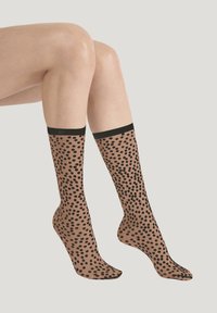 Doorzichtige bruine kniekousen met een zwart stippenpatroon en effen zwarte boorden. Gestructureerde stof en een gladde afwerking.
