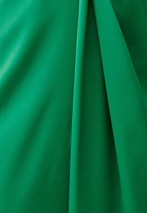 Grüner Stoff mit einer glatten, matten Textur, der weiche Drapierungen und Falten aufweist. Ideal für Bekleidung oder Polsterung.