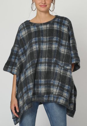 Poncho a cuadros en gris, azul marino y azul, hecho de suave felpa. Presenta un corte holgado, mangas cortas, un cuello amplio y un bolsillo lateral.