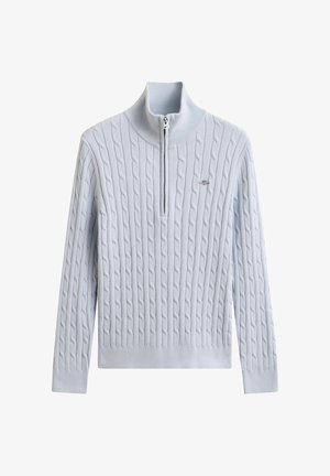 Lichtblauwe kabelgebreide trui met lange mouwen, kwart-ritskraag en een klein geborduurd logo op de borst.