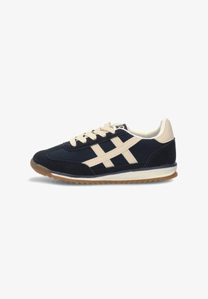 Zapatillas de deporte azul marino con acentos beige, que presentan material de ante y malla, punta redonda, diseño de cordones y suela de goma.